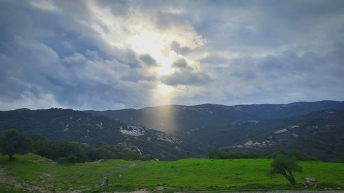 Scenic view of mountains against cloudy sky