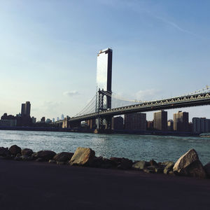 View of bridge over sea against buildings