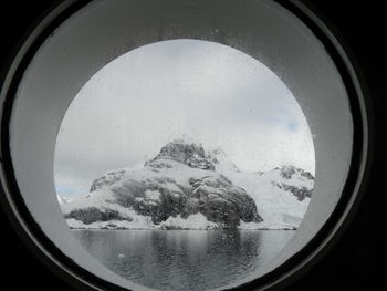 View of snowcapped mountains seen through window