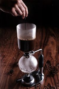 Cropped hand of person pouring coffee on table