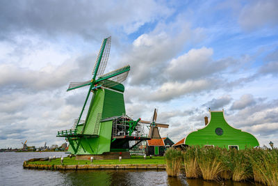 Traditional windmill on field against sky