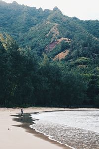 Scenic view of sea by mountains against sky