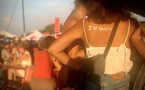 Rear view of young woman standing in a music festival