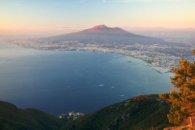 Aerial view of city by sea against sky