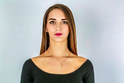 Portrait of young woman against gray background