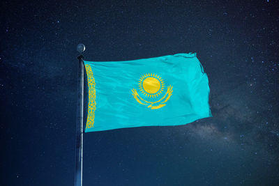 Low angle view of kazakhstan flag against star field sky
