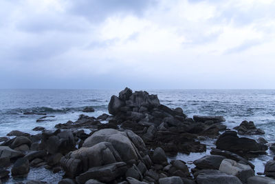Rocks on sea shore against sky