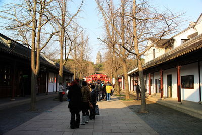 People walking on footpath in city