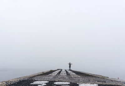 Man standing by sea against clear sky