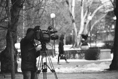 Reflection of man photographing on camera