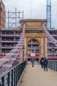 People walking on bridge against sky