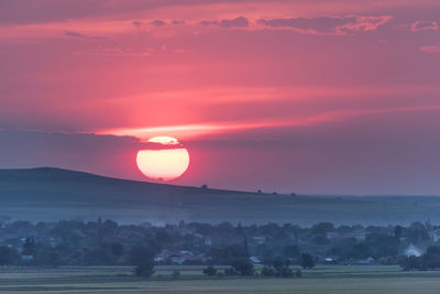 Scenic view of landscape against orange sky