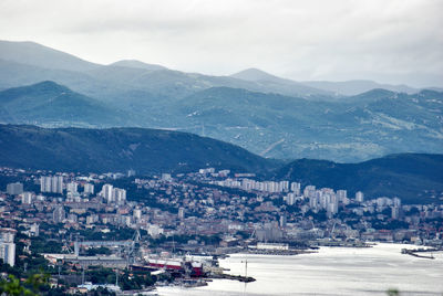 Aerial view of buildings in city against sky