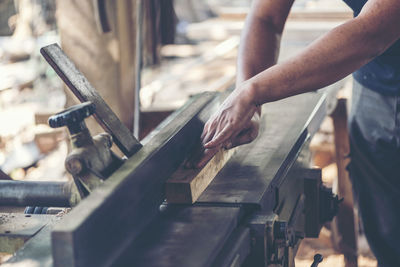 Midsection of carpenter working in workshop