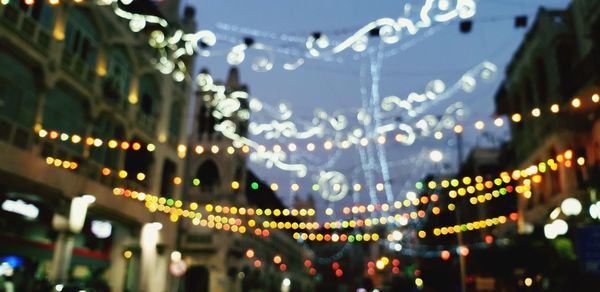 Defocused image of illuminated lights in city at night