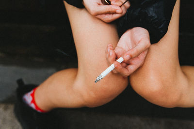 Low section of woman with cigarette