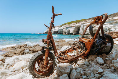 Rusty metal on beach against clear sky