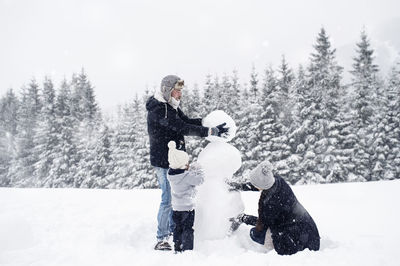 Family building snowman together