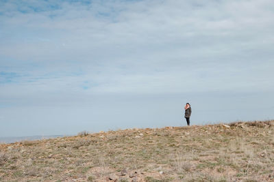 Woman standing on field against sky