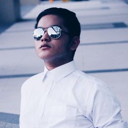 Young man wearing sunglasses while standing in corridor