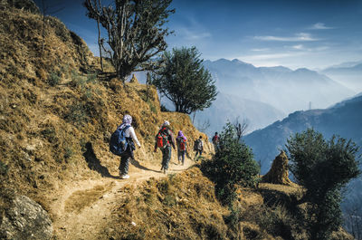 People on mountain against sky