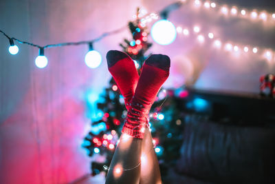 Midsection of woman with illuminated lights at night