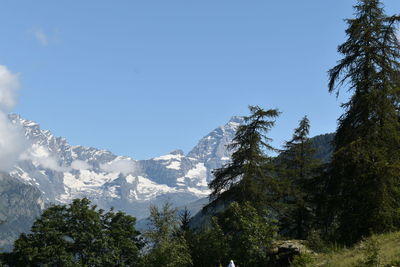 Low angle view of snowcapped mountains against clear sky