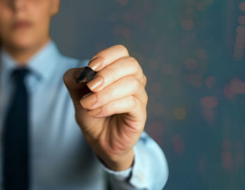 Midsection of man holding mobile phone