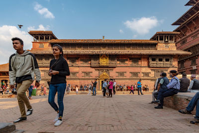 Group of people walking against built structure