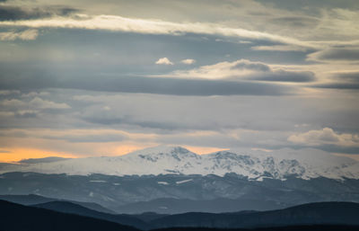 Scenic view of snowcapped mountains against sky during sunset