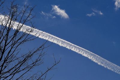 Low angle view of vapor trail against blue sky