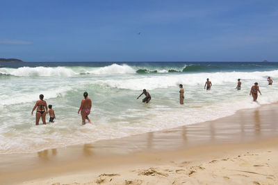 People on beach against sky