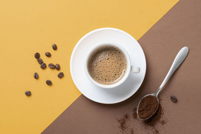 Directly above shot of coffee on yellow background