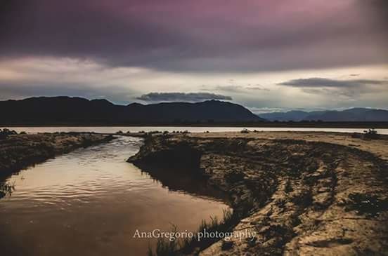 water, sky, mountain, cloud - sky, tranquil scene, cloudy, tranquility, lake, scenics, beauty in nature, mountain range, cloud, nature, overcast, non-urban scene, landscape, idyllic, outdoors, no people, weather, calm, remote, day, the way forward, non urban scene, hill, rippled, travel destinations, horizon over land