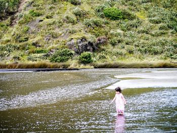 Rear view of man standing in lake