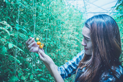 Portrait of woman holding plants