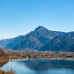 Scenic view of lake and mountains against clear blue sky