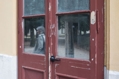 Reflection of man on glass door of building