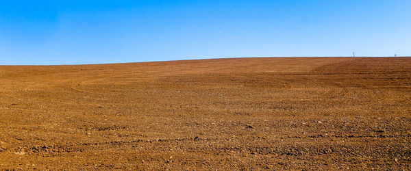 Scenic view of desert against clear blue sky