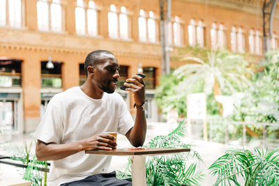 Man talking on phone while sitting at cafe