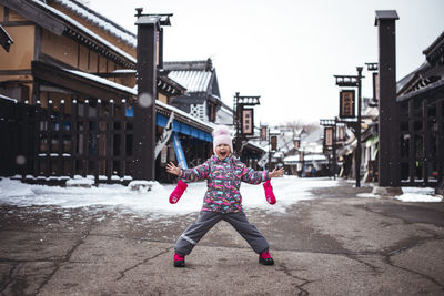 Full length of excited child on snow covered land