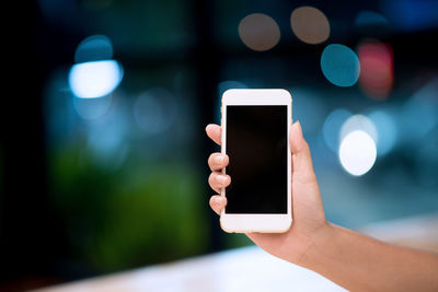 Close-up of human hand holding smart phone at home