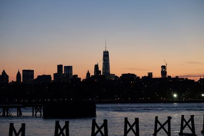 One world trade center in city against sky during sunset