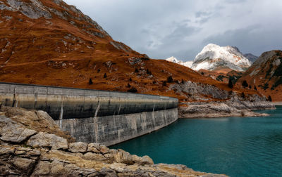 Scenic view of lake by mountain against sky