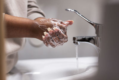 Mid section of woman washing hands