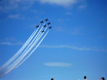 Low angle view of airshow against blue sky