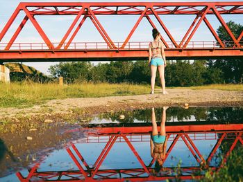 Woman standing on tree trunk