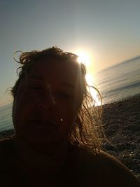 Portrait of man on beach against sky during sunset