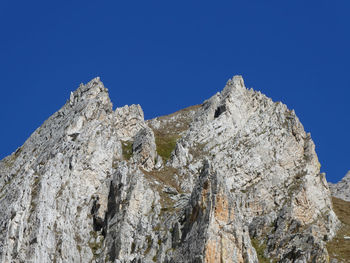 Low angle view of rocks against blue sky