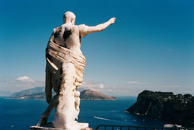 Statue of sea against blue sky